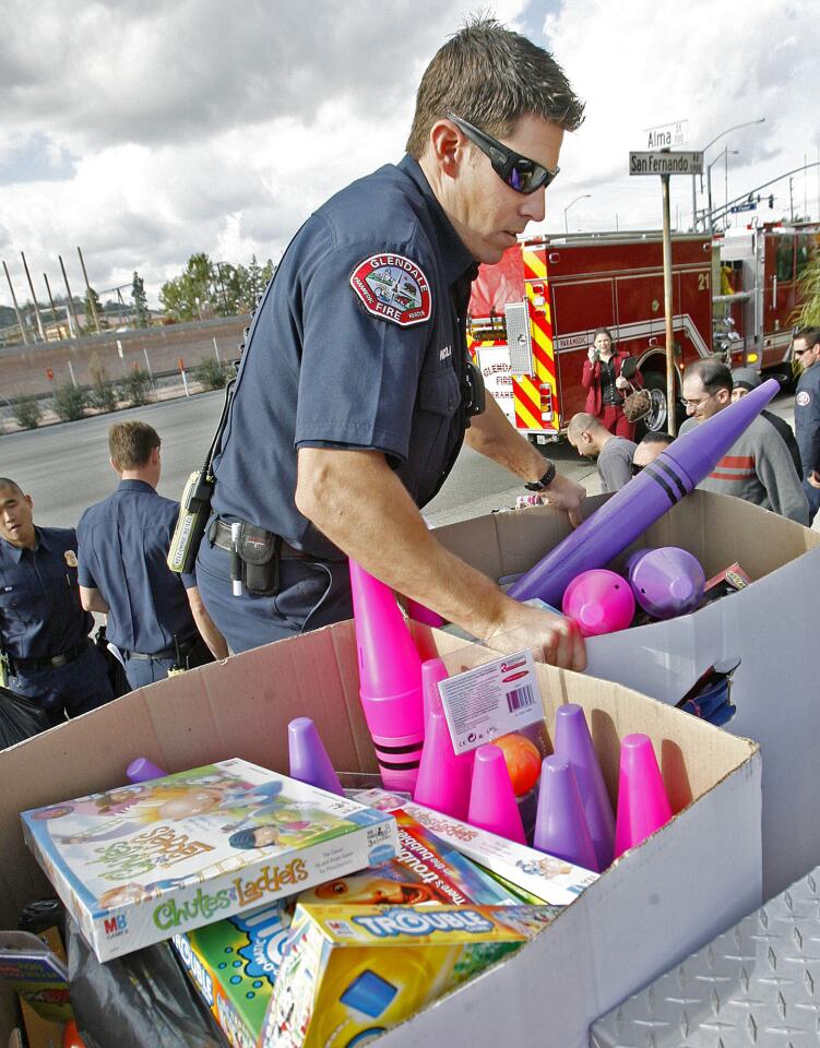 Glendale Fire paramedic Tom Nicola loads toys onto a fire department pickup in Glendale at 4Over, Inc. on Friday, December 14, 2012. Employees at 4Over, Inc. collected $5,000 in donations to purchase new toys to the 20th Annual ABC7 Spark of Love toy drive with the Glendale Fire Department.