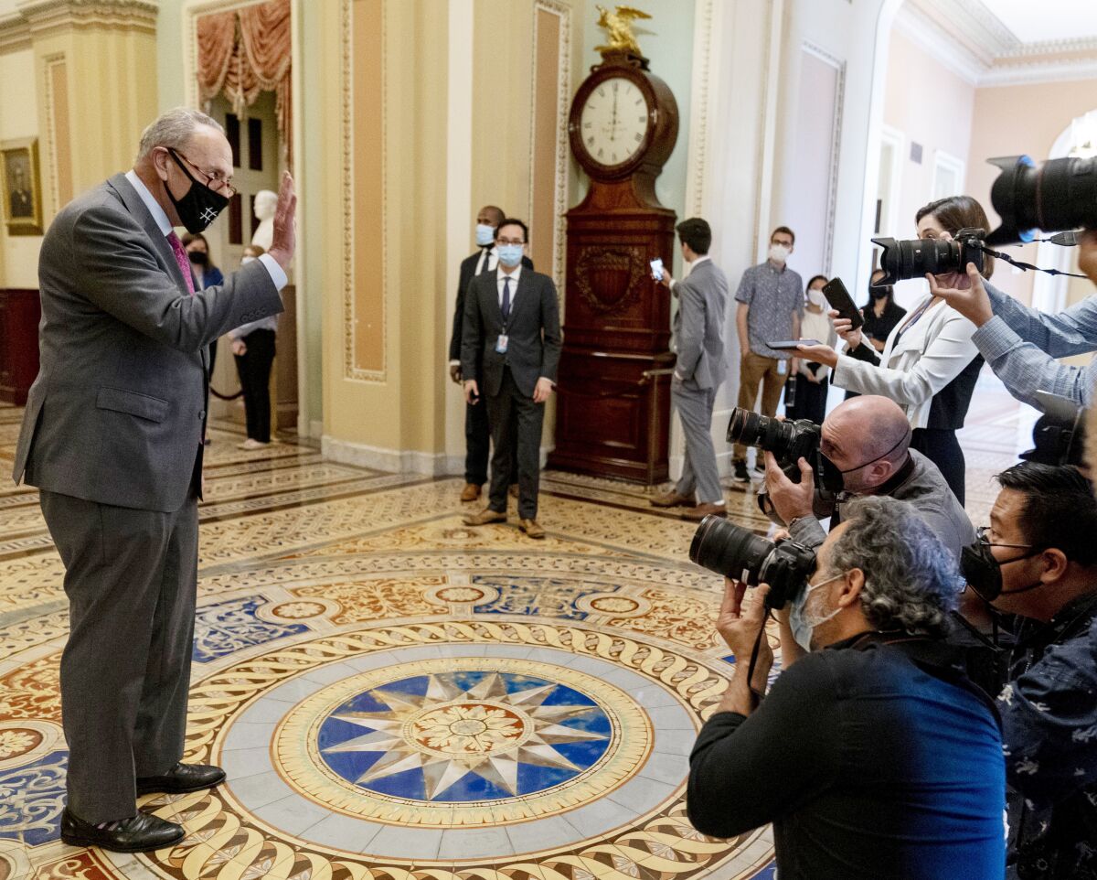 Senate Majority Leader Chuck Schumer of N.Y. walks off the Senate floor and speaks to members of the media as the Senate approves a $1 trillion bipartisan infrastructure bill, sending a cornerstone of the Biden agenda to the House, on Capitol Hill in Washington, Tuesday, Aug. 10, 2021. (AP Photo/Andrew Harnik)