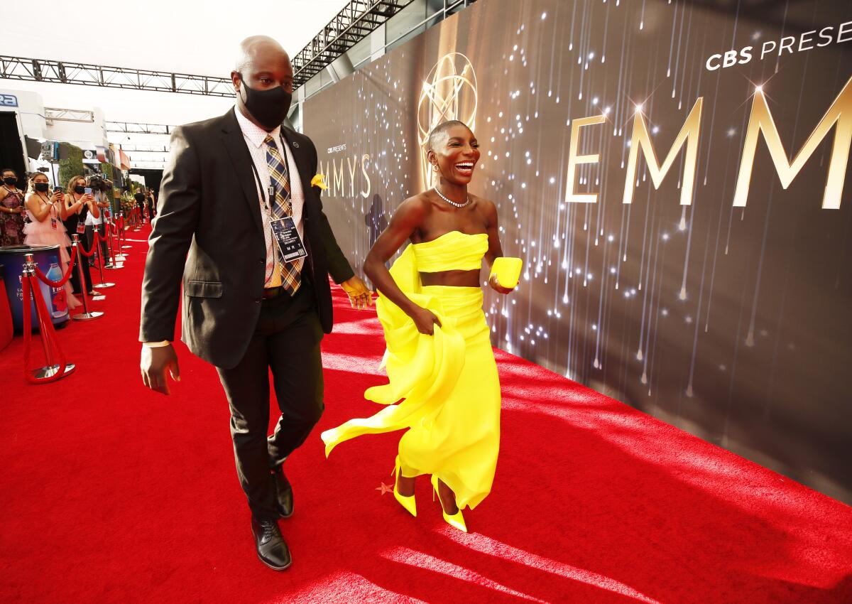 Michaela Coel, in a yellow outfit and heels, arrives on the red carpet 
