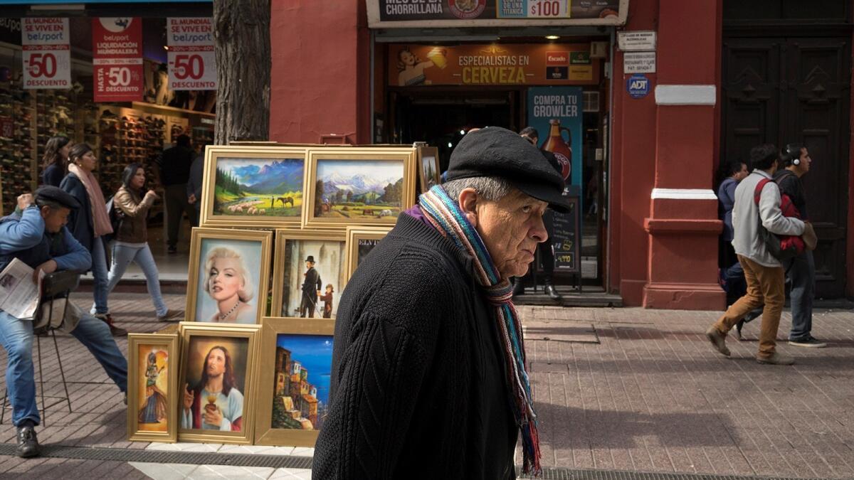 Santiago, Chile | Susan Weber, PasadenaWeber spent two weeks in Chile on a trip that included the Atacama Desert and Easter Island, also known as Rapa Nui. She was in Santiago, the capital, on her last travel day when she took this shot of a man passing paintings on t