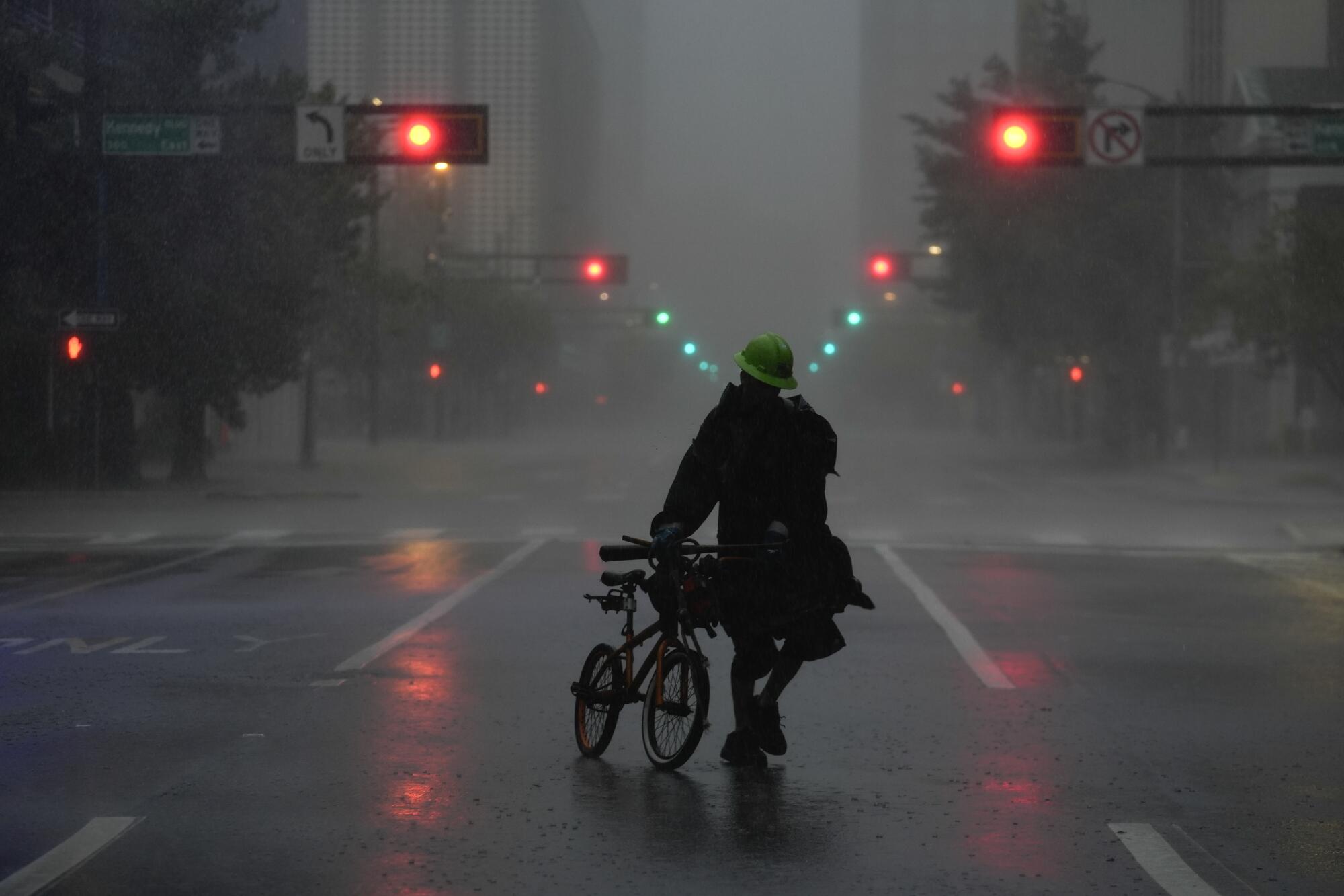 Ron Rook camina entre el viento y la lluvia en una calle desierta del centro de Tampa.