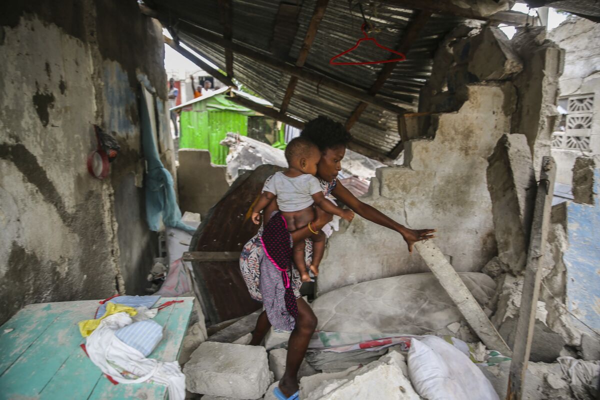 A firefighter searches for survivors inside a damaged building, after the 7.2 magnitude earthquake in Les Cayes, Haiti