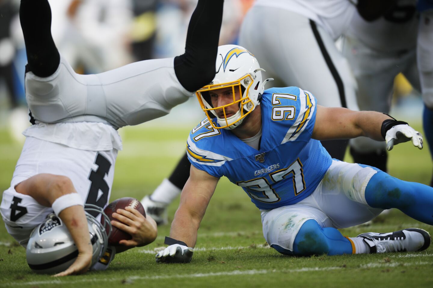 Oakland Raiders Derek Carr is hit by Chargers defensive end Joey Bosa during the second quarter.
