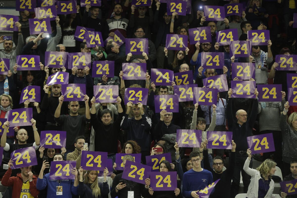 Spectators pay tribute to basketball legend Kobe Bryant prior to the start of the Italian Basketball second division match between Rieti and Scafati in Rieti's PalaSojourne, Italy, Wednesday, Feb. 5, 2020. Bryant spent seven years of his childhood in Rieti, where his father, Joe Bryant, made his Italian basketball debut in 1984 when Kobe was 6 years-old. (AP Photo/Gregorio Borgia)