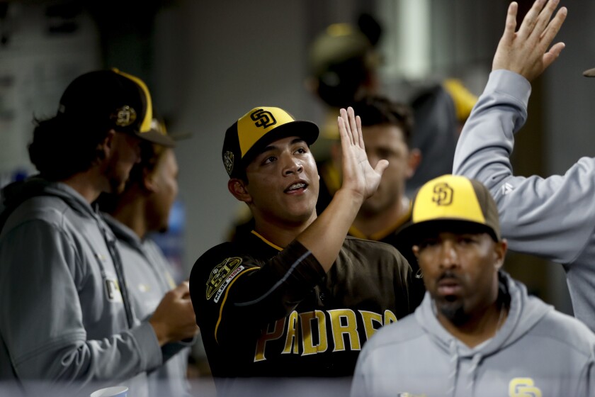 San Diego Padres relief pitcher Andres Munoz, center, is greeted in the dugout during the sixth inning of the team's baseball game against the Atlanta Braves, Friday, July 12, 2019, in San Diego.