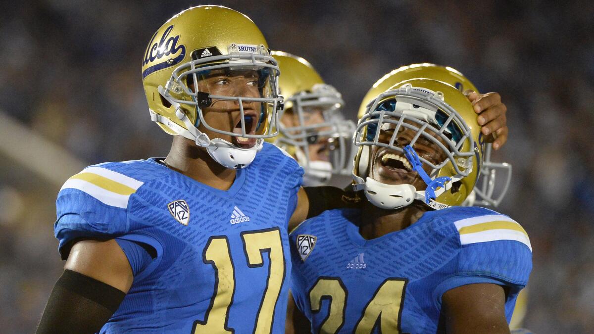 UCLA quarterback Brett Hundley, left, and running back Paul Perkins celebrate a touchdown against Nevada last season. Count Virginia Coach Mike London among the Hundley admirers.