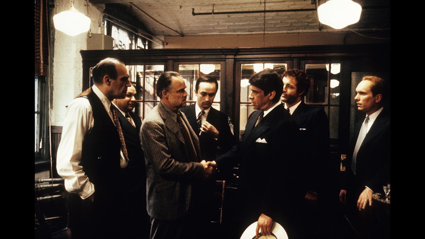 Abe Vigoda, left, and Robert Duvall watch Marlon Brando and Al Lettieri shake hands in a scene from the film "The Godfather" in 1972.