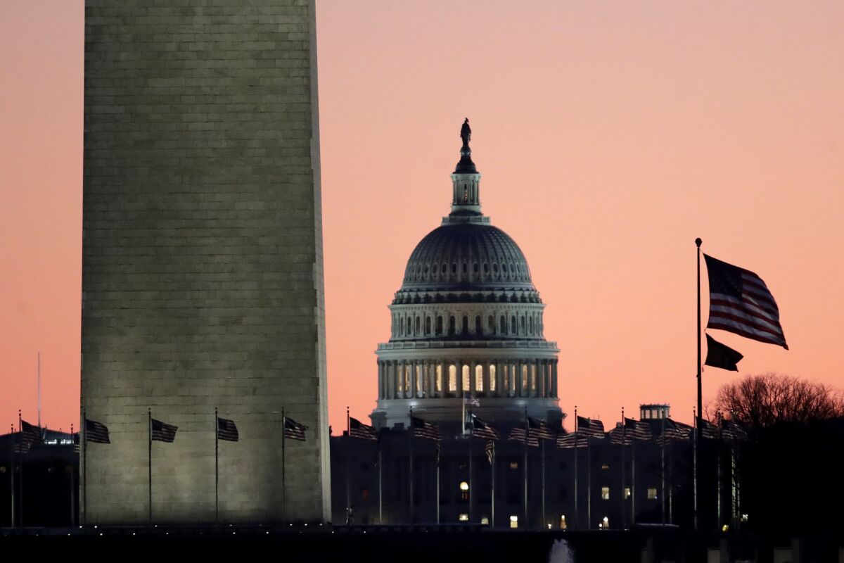 U.S. Capitol at sunrise with the Washington Monument in the foreground.