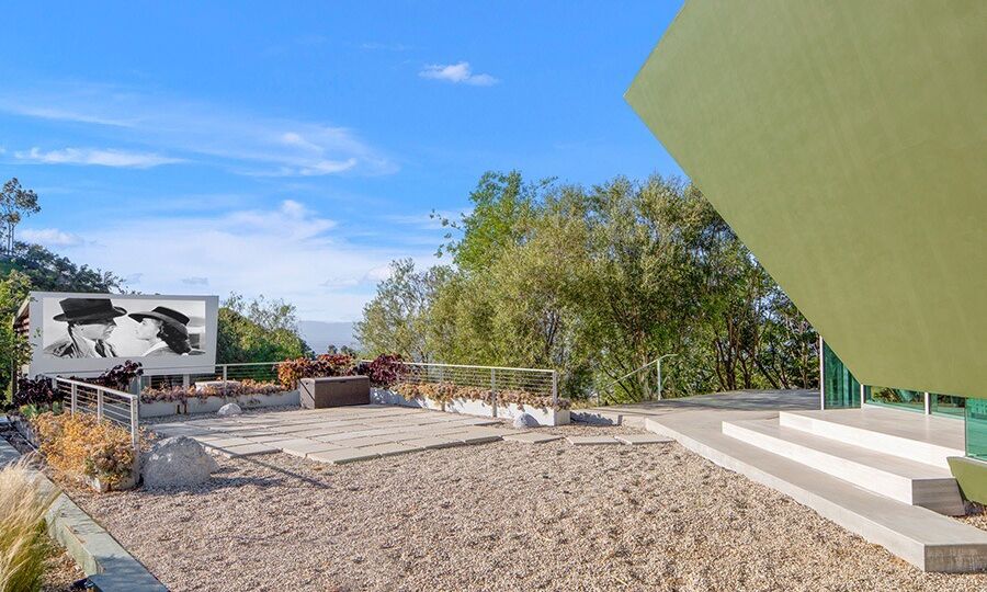 The movie theater is outdoors with seating and a large screen.