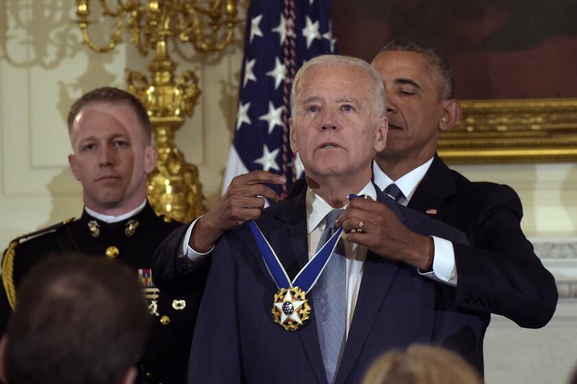 President Barack Obama presents Vice President Joe Biden with the Presidential Medal of Freedom during a ceremony in the State Dining Room of the White House in Washington, Jan. 12, 2017. (AP Photo/Susan Walsh)