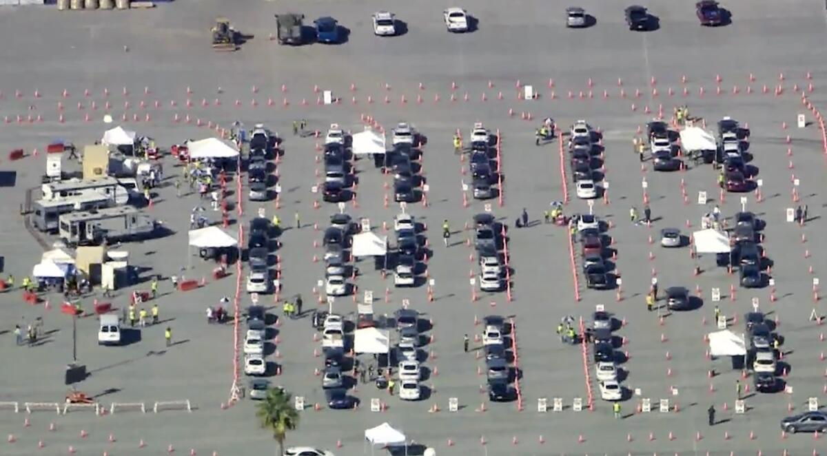 An aerial view of cars in a parking lot alongside tents and trailers.