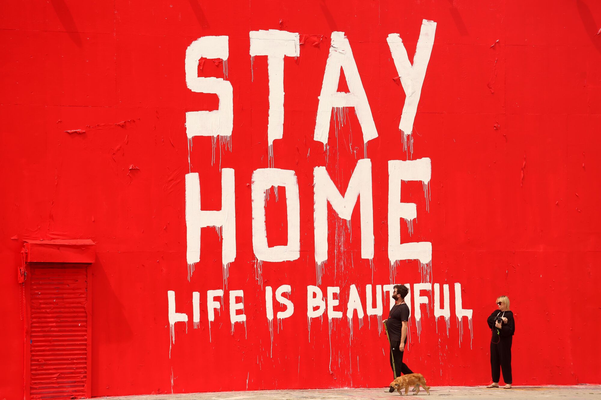 A message painted on a wall on La Brea Avenue on March 31 reads: "Stay home. Life is beautiful."