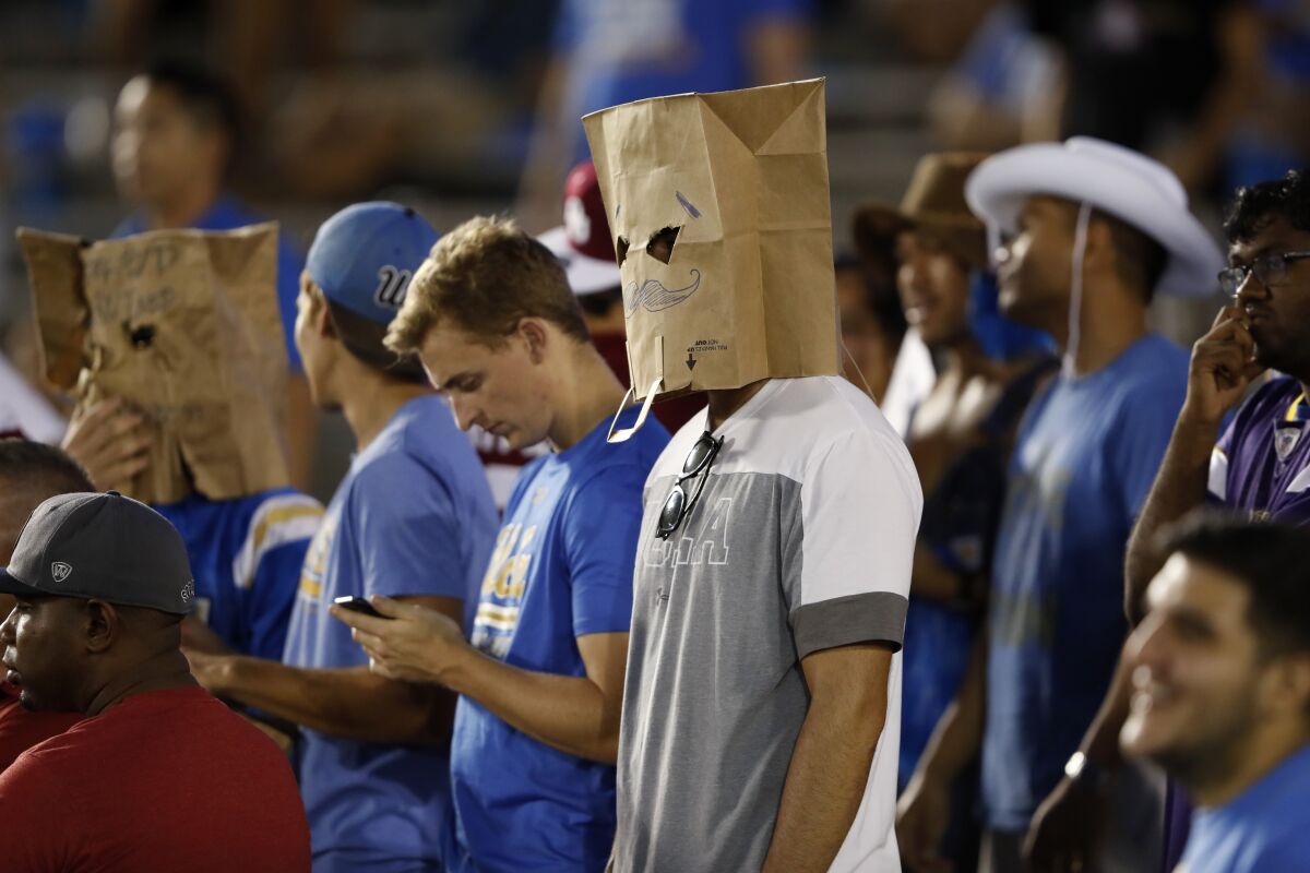UCLA fans wear paper bags over their heads.