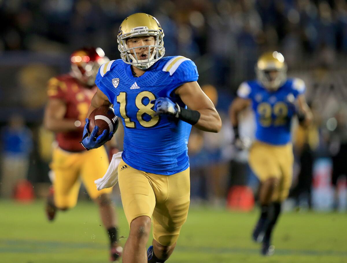 UCLA receiver heads toward the endzone after a 57-yard catch and run during the first quarter against USC on Saturday at the Rose Bowl.