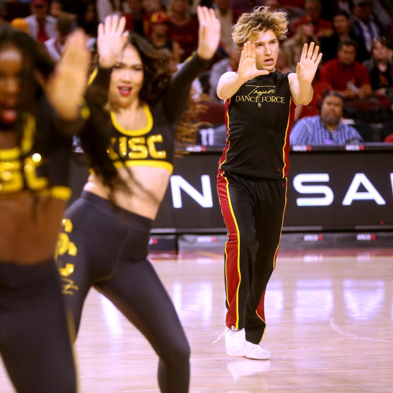 Hugo Miller, right, performs with the Trojan Dance Force during a game at Galen Center.