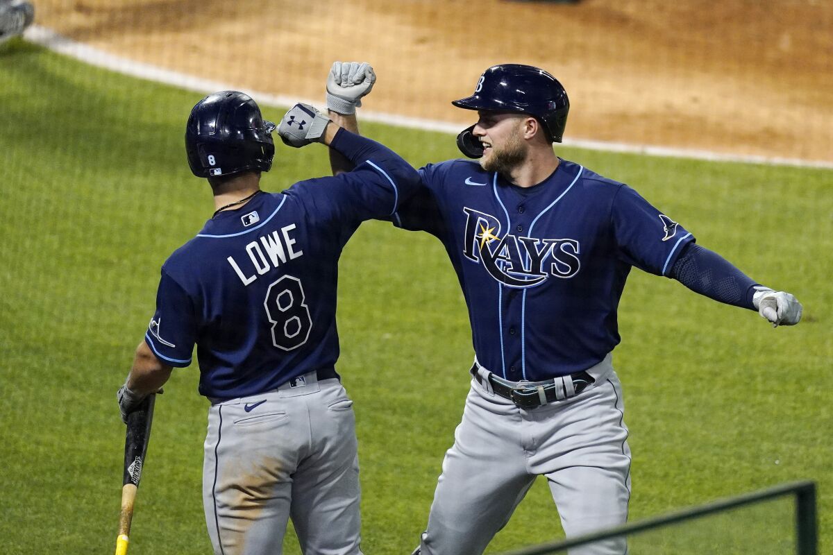 Tampa Bay Rays' Austin Meadows, right, is congratulated by Brandon Lowe hits a solo home run during the seventh inning of a baseball game against the Los Angeles Angels Tuesday, May 4, 2021, in Anaheim, Calif. (AP Photo/Mark J. Terrill)