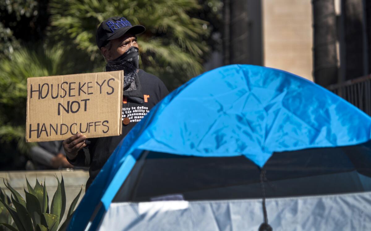 A man who goes by the name of General Dogon protests a plan to remove homeless  encampments in L.A.