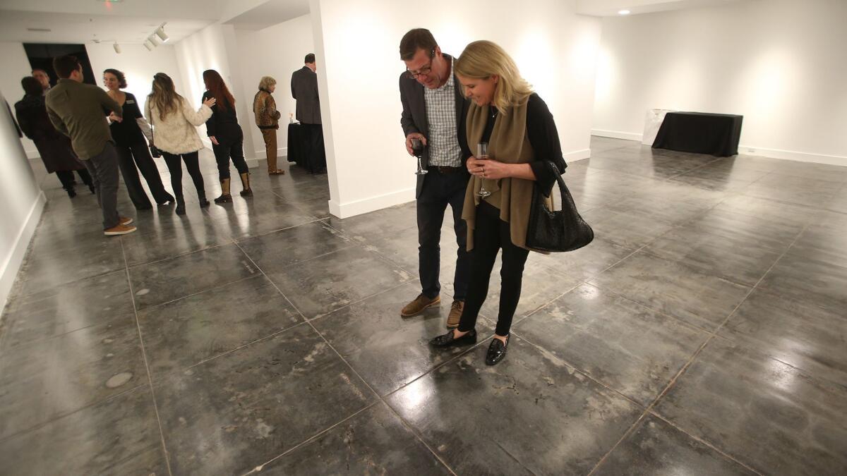 A couple explore the lower level of the Laguna Art Museum during a celebration Thursday after restoration of the original floor from 1934.