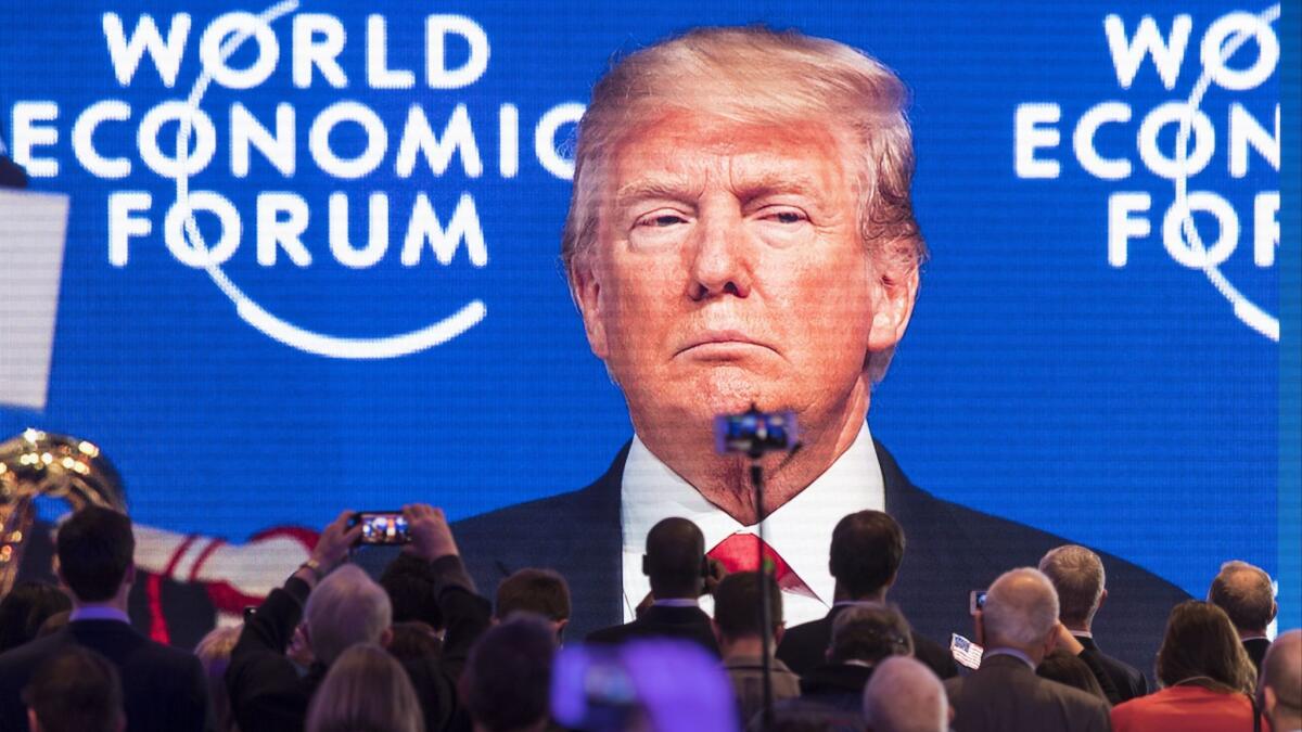 Bigger than life, but smaller economic growth than he wished: President Trump appears on a screen as he addresses the the big Davos, Switzerland, economic meeting on Friday.