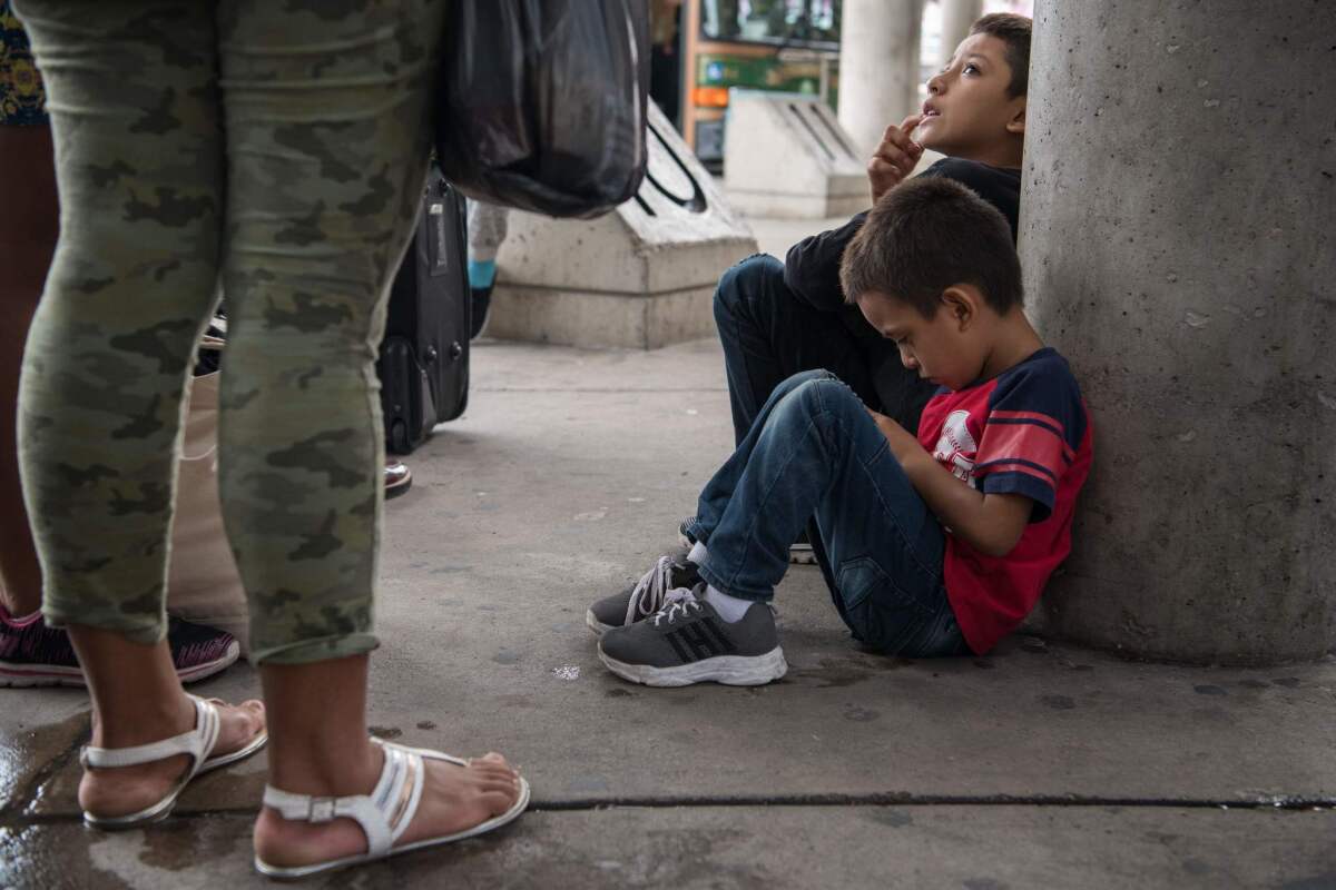 Central American migrant families recently released from federal detention wait to board a bus at a bus depot in McAllen, Texas, this month.