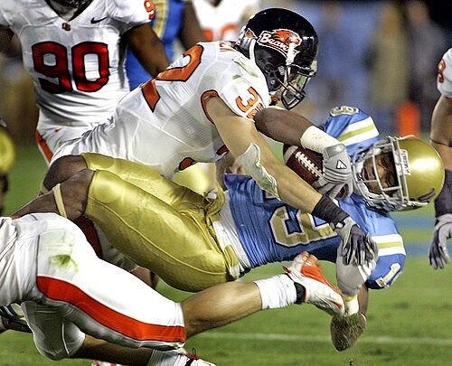 Oregon State's Keaton Kristick brings down UCLA's Dominique Johnson for a loss during the third quarter Saturday.