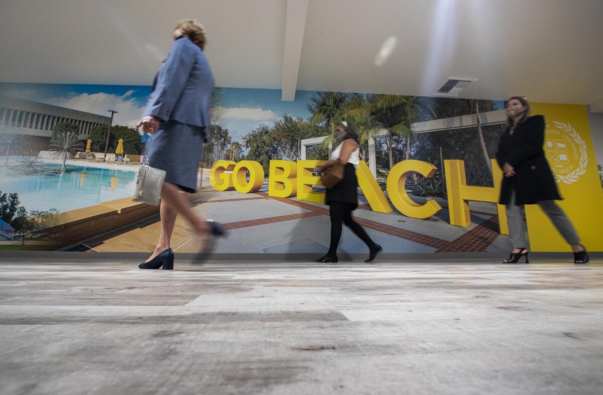 Carol Hansen, left, Marisa Cardenas-Joslyn, center, and Julianne Hoefer walk past a mural.