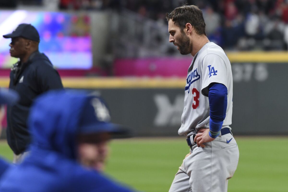 Chris Taylor walks back to the Dodgers dugout after being caught in a rundown to end the top of the ninth inning.