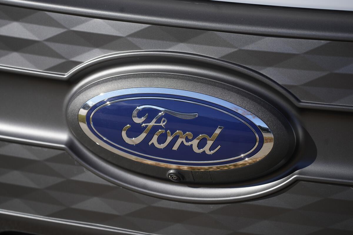 The Ford company logo shines off the grille of an unsold 2023 F-150 Lightning pickup truck.