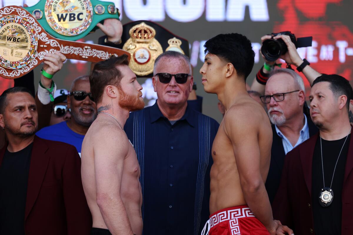 Canelo ?lvarez, left, and Jaime Munguia stare at one another during their weigh-in Friday.