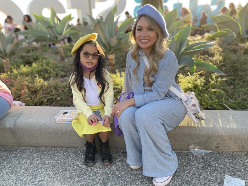 Mother and daughter BTS fans wear coordinated berets.