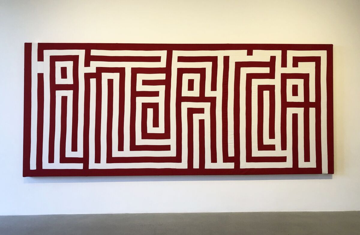 A hanging wall collage made from red and white stripes looks like a labyrinth that spells "America."