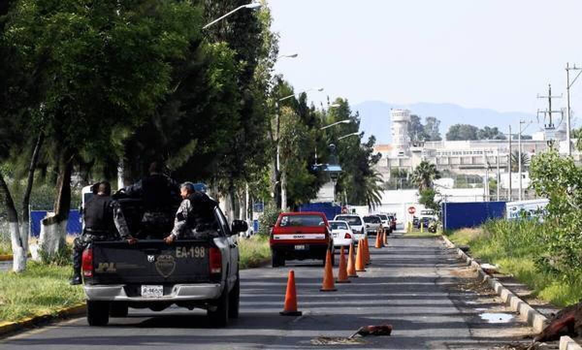 Police officers head to the Puente Grande state prison, background, in Zapotlanejo, where the Mexican drug cartel boss who killed a U.S. narcotics agent in 1985 was freed on a technicality last week.