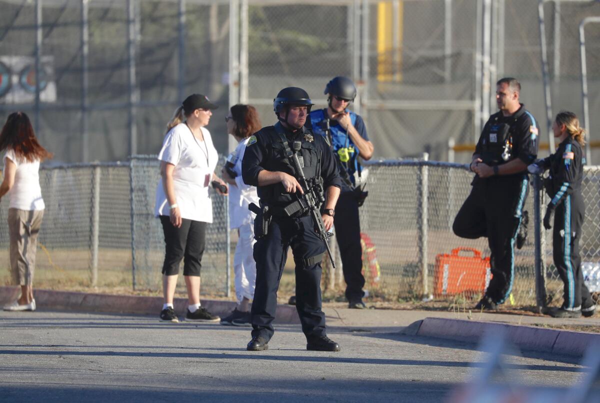 A police officer stands guard outside Gilroy High School soon after a gunman killed three people on July 28 at the nearby Gilroy Garlic Festival in Northern California.
