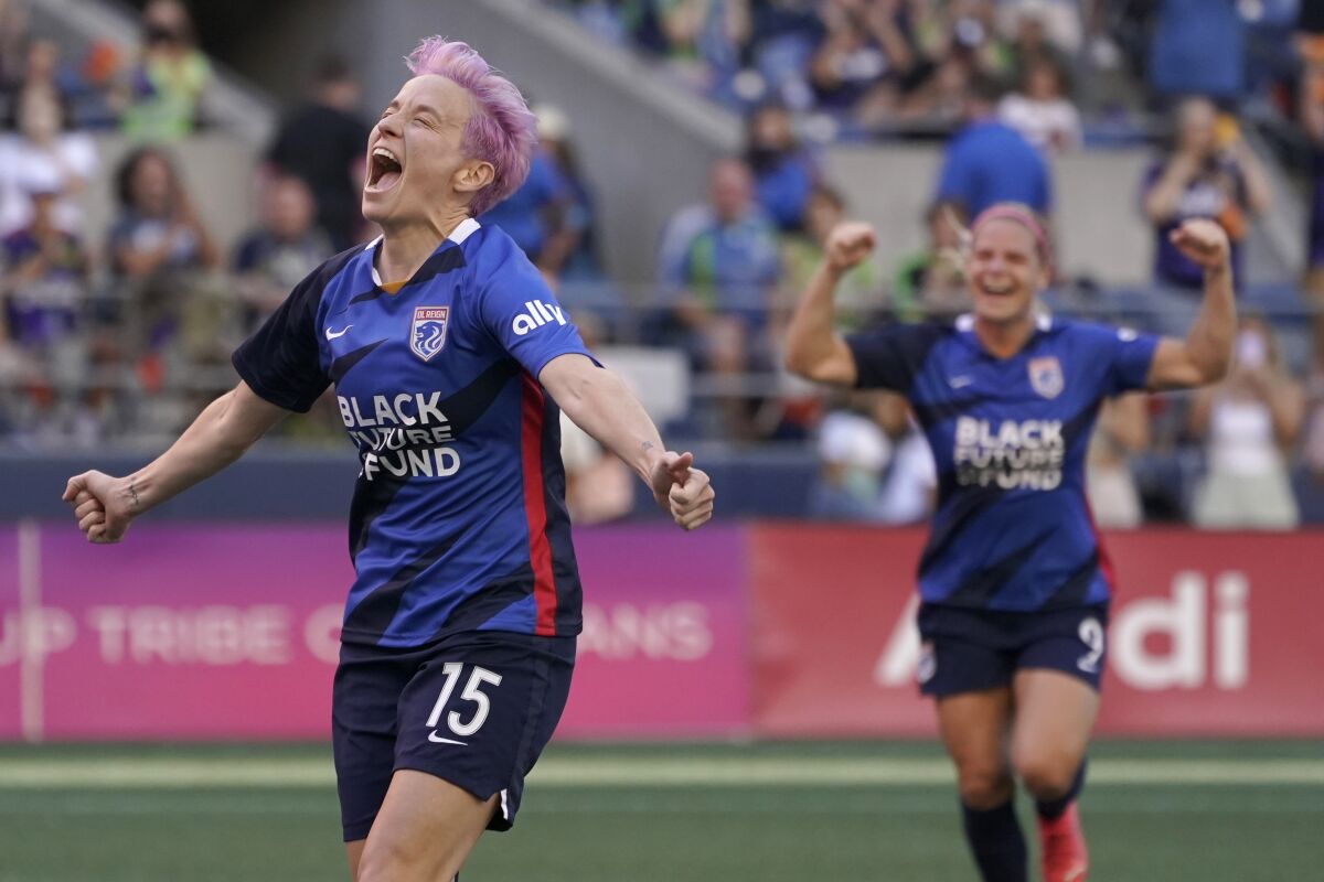OL Reign forward Megan Rapinoe, left, celebrates with Eugenie Le Sommer, right, after scoring a goal on a penalty kick against the Portland Thorns during the first half of an NWSL soccer match, Sunday, Aug. 29, 2021, in Seattle. The goal was Rapinoe's second during the first half. (AP Photo/Ted S. Warren)