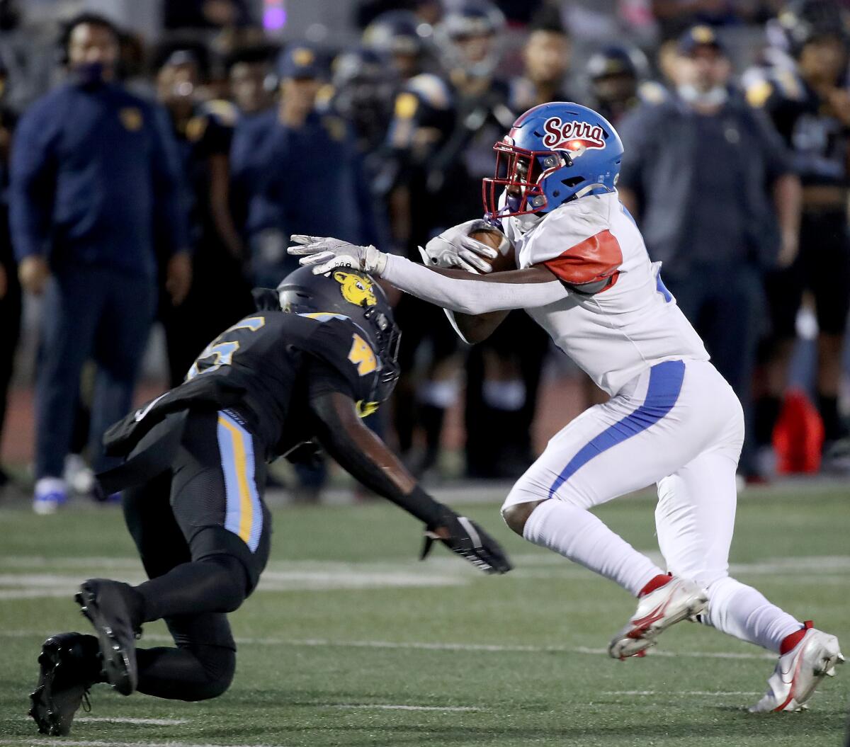 Serra running back Troy Crozier tries to evade a tackle by Warren cornerback Connish Jaylon.