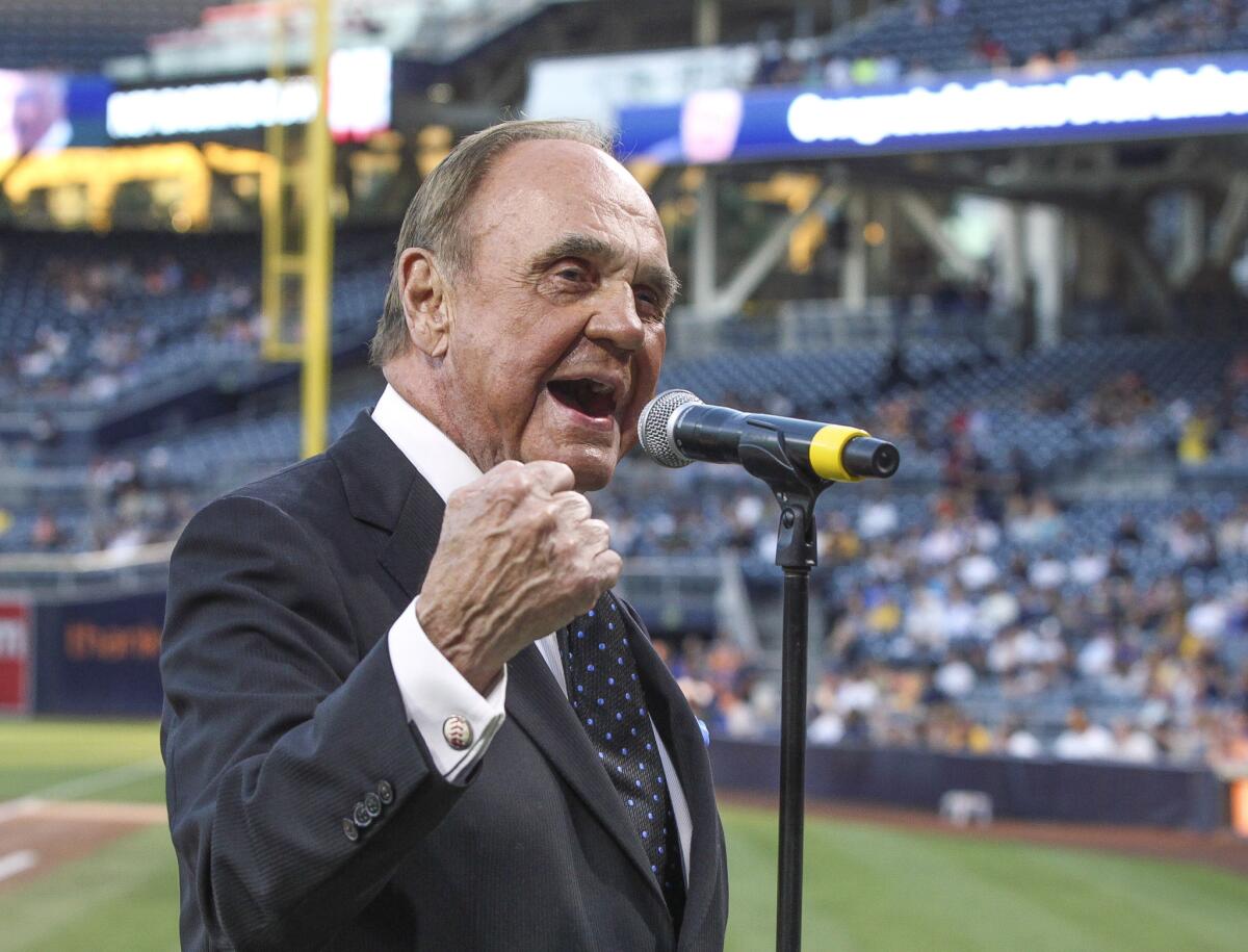 Padres television announcer Dick Enberg says "Oh my!" for the crowd during a pregame ceremony honoring the end of his sports broadcasting career.