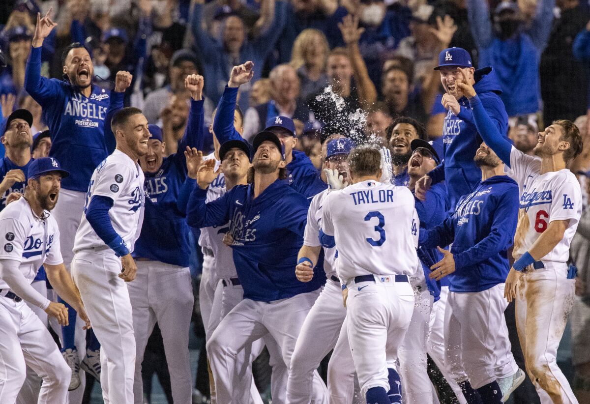 Dodgers celebrate as Chris Taylor approaches home plate after his two-run homer wins Wednesday's game.
