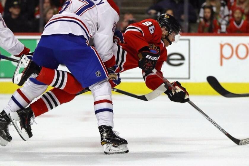 Blackhawks forward Patrick Kane is shoved to the ice by Canadiens forward Max Pacioretty as he shoots and scores during the second period of a game on Sunday.