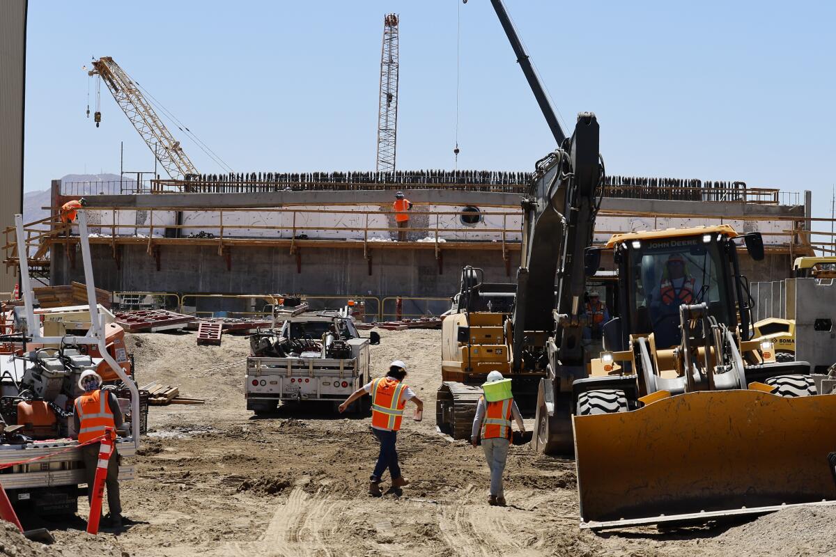 Workers, vehicles and equipment at a construction site.