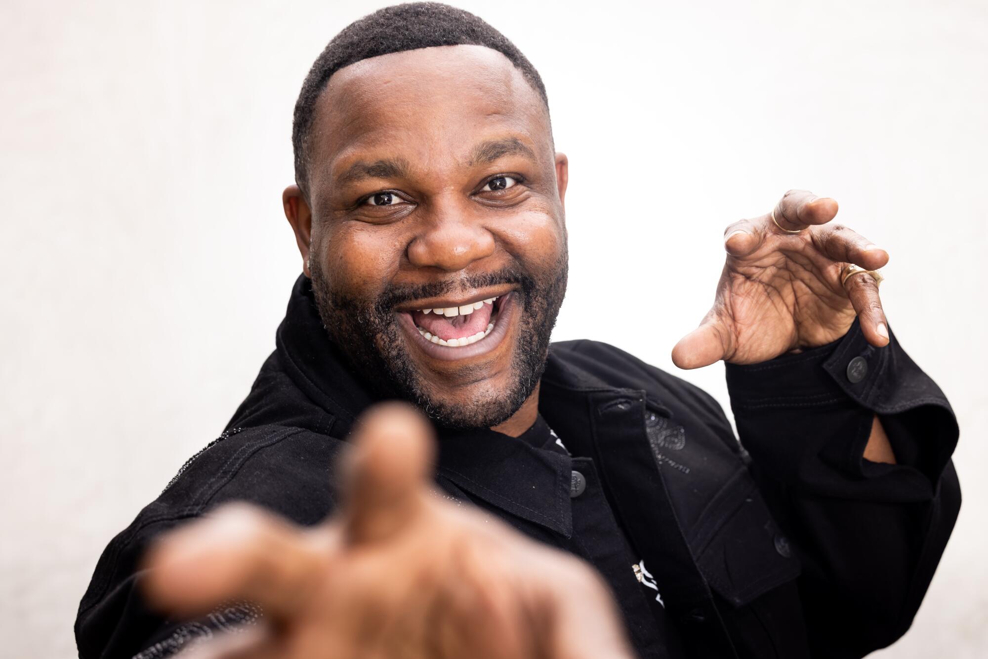 Man smiling waving his hands in front of the camera