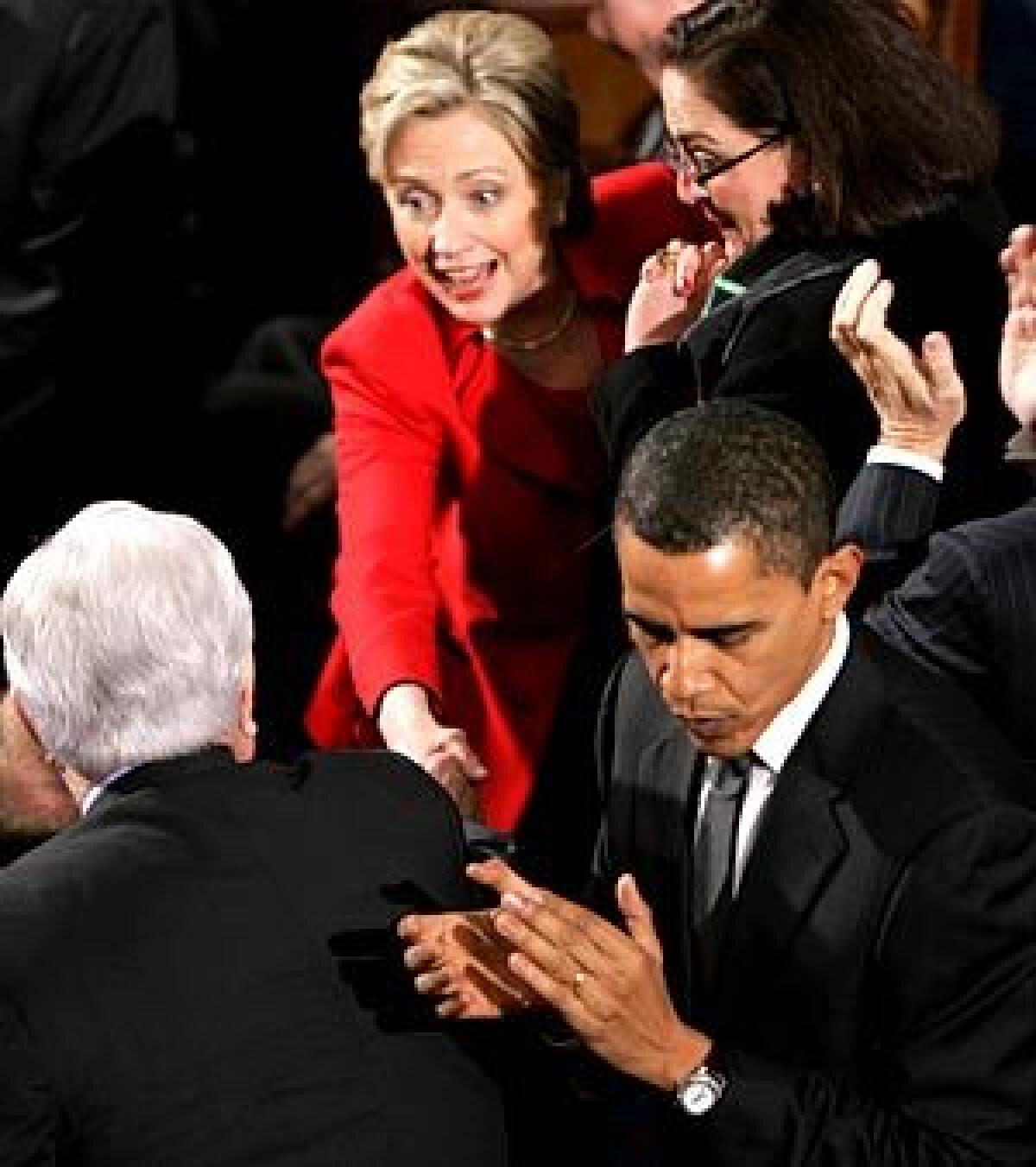 Sen. Hillary Rodham Clinton greets Sen. Edward Kennedy, back to camera, as Sen. Barack Obama turns away before President Bush's State of the Union address in Washington.