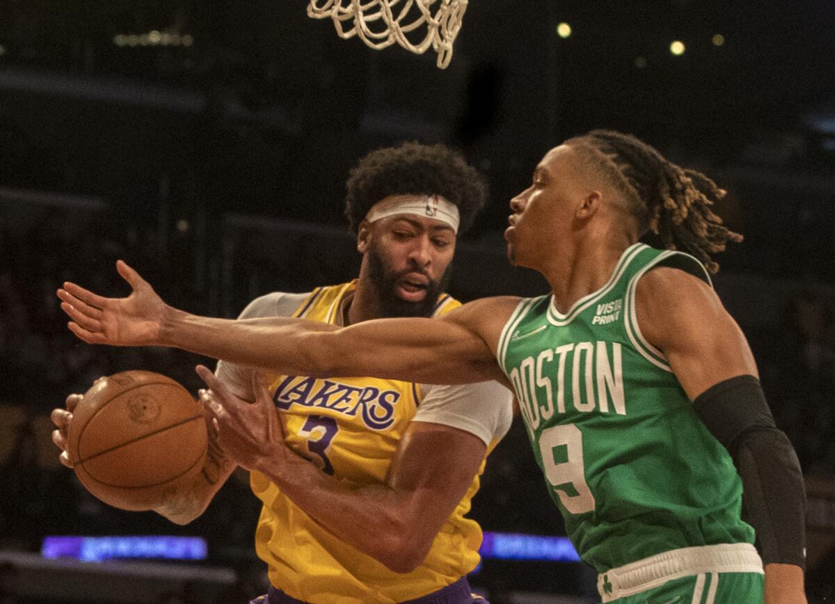 Lakers forward Anthony Davis grabs a rebound from Boston Celtics guard Romeo Langford.