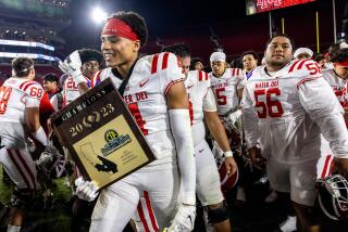 LOS ANGELES, CA - NOVEMBER 24, 2023: Mater Dei Cabin Brown (4) holds the championship plaque after his team beat St John Bosco 35-7 to win the Southern Section Division I football championship at the LA Memorial Coliseum on November 24, 2023 in Los Angeles, California.(Gina Ferazzi / Los Angeles Times)