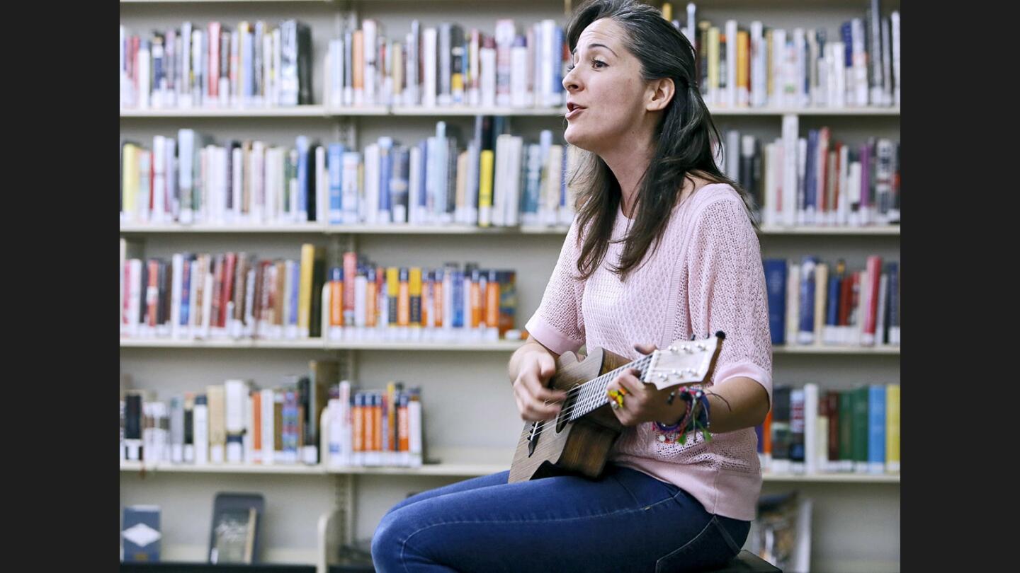 Music teacher Sara Quintanar plays some of her English-Spanish songs for children at the Pacific Park Library in Glendale on Thursday, June 29, 2017. Quintanar, who has been teaching at Franklin Magnet School since 2010, performed during story time and also showed her new children's E-book, Dragon World.