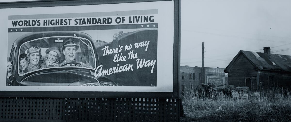 A billboard reads 'World's highest standard of living: There's no way like the American way,' from the documentary 'Capital in the Twenty-First Century'