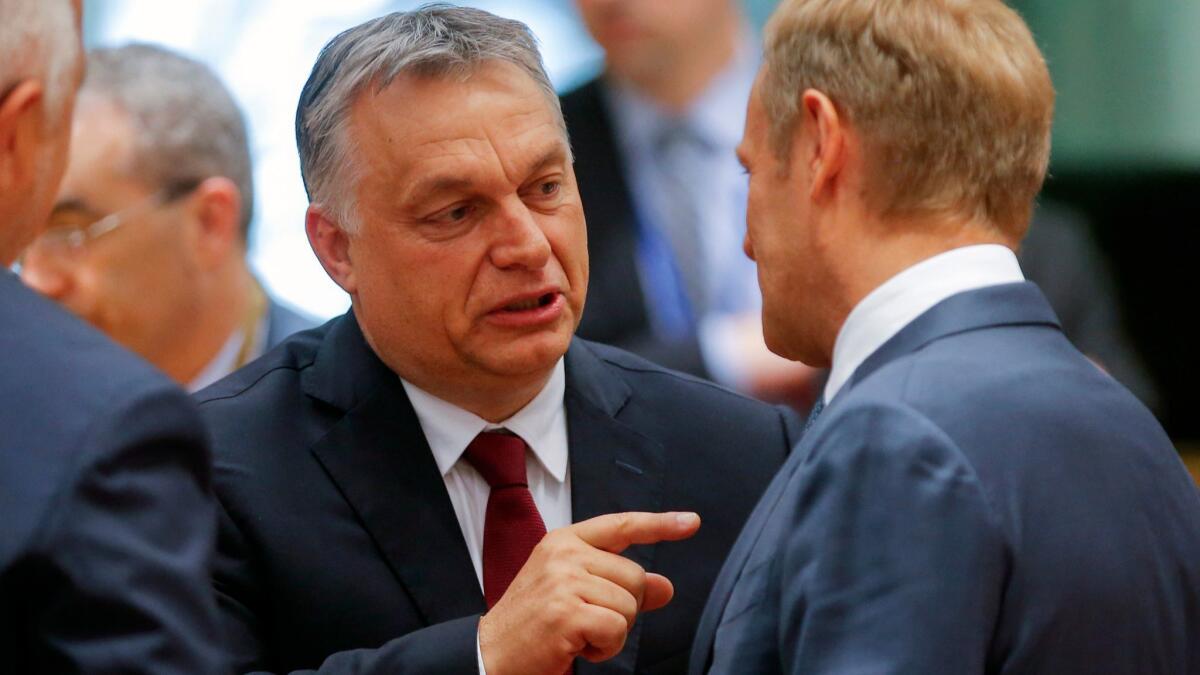 Hungarian Prime Minister Viktor Orban left, and European Council President Donald Tusk of Poland are shown during a European Council summit in Brussels on June 28, 2018.