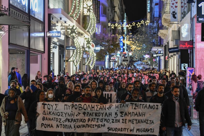 Protesters hold a banner which reads in Greek "they shot them because they were Roma" as they protest the shooting in the head of a 16-year-old youth, in central Athens Monday Dec 5, 2022. A police officer has been arrested in northern Greece after a 16-year-old boy was shot in the head and seriously injured during a car chase after he allegedly failed to pay the bill at a gas station(AP Photo/Michael Varaklas)