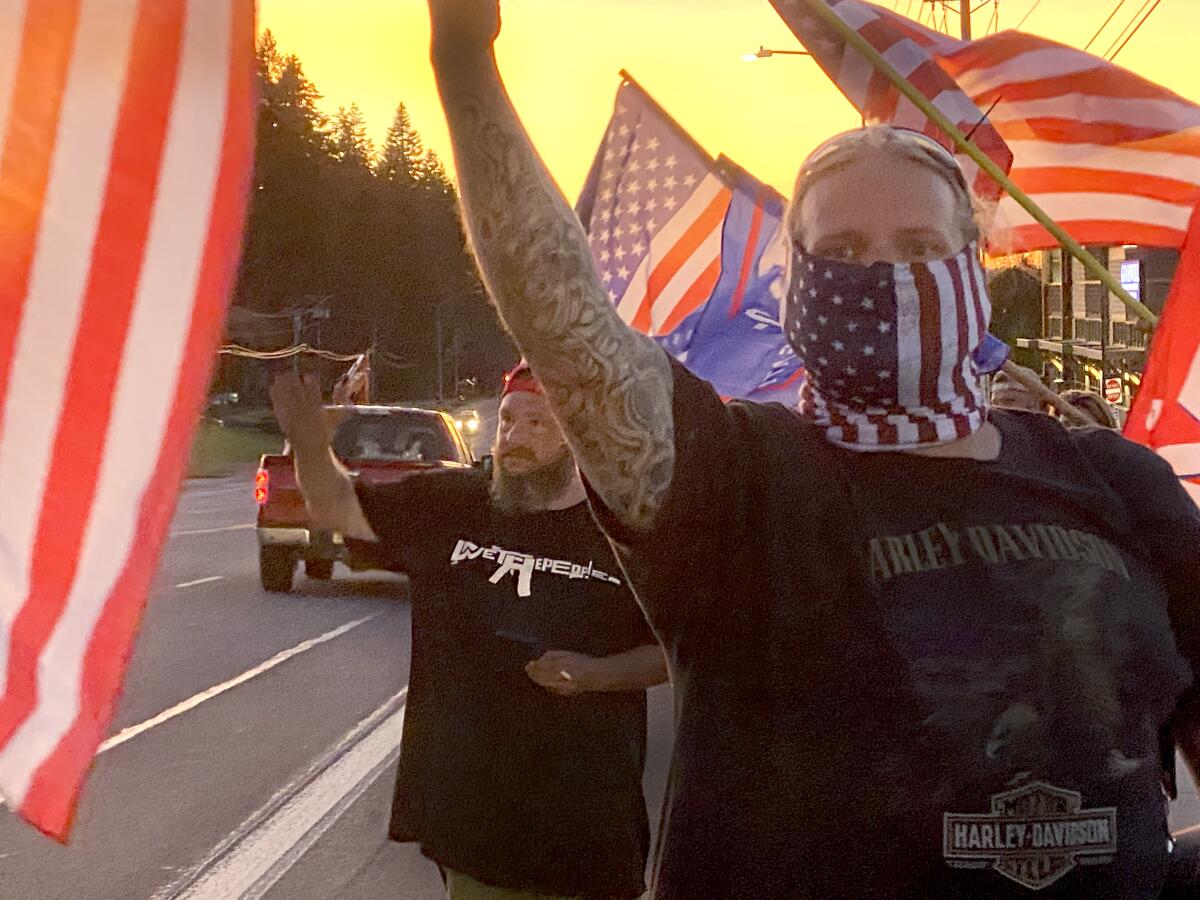 People wave U.S. and Trump campaign flags at a protest