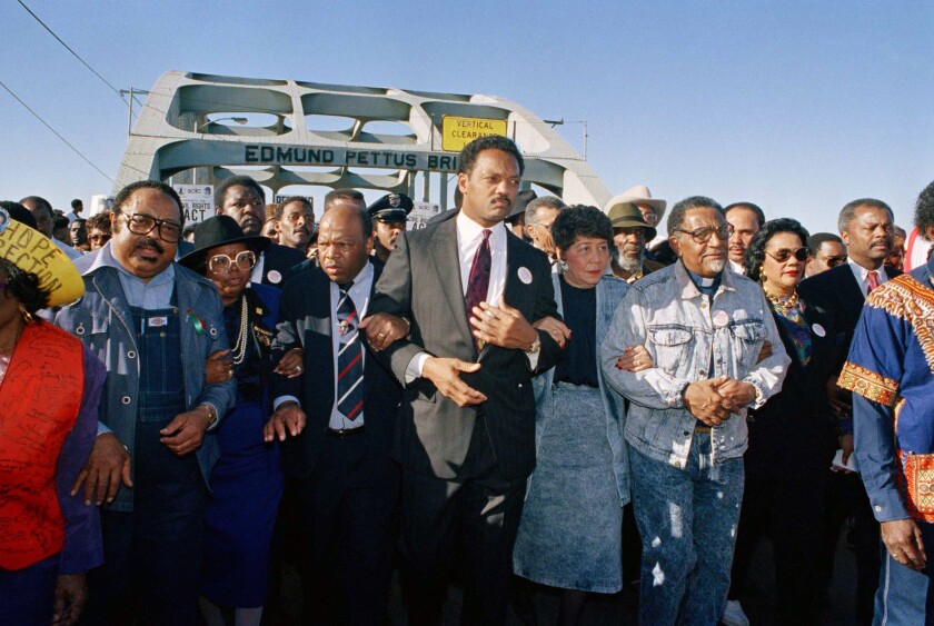 FILE - In this March 4, 1990, file photo, civil rights figures lead marchers across the Edmund Pettus Bridge during the recreation of the 1965 Selma to Montgomery march in Selma, Ala. From left are Hosea Williams of Atlanta, Georgia Congressman John Lewis, the Rev. Jesse Jackson, Evelyn Lowery, SCLC President Joseph Lowery and Coretta Scott King. This Sunday, March 7, 2021, marks the 56th anniversary of those marches and "Bloody Sunday," when more than 500 demonstrators gathered on March 7, 1965, to demand the right to vote and cross Selma's Edmund Pettus Bridge. They were met by dozens of state troopers and many were severely beaten. (AP Photo/Jamie Sturtevant, File)