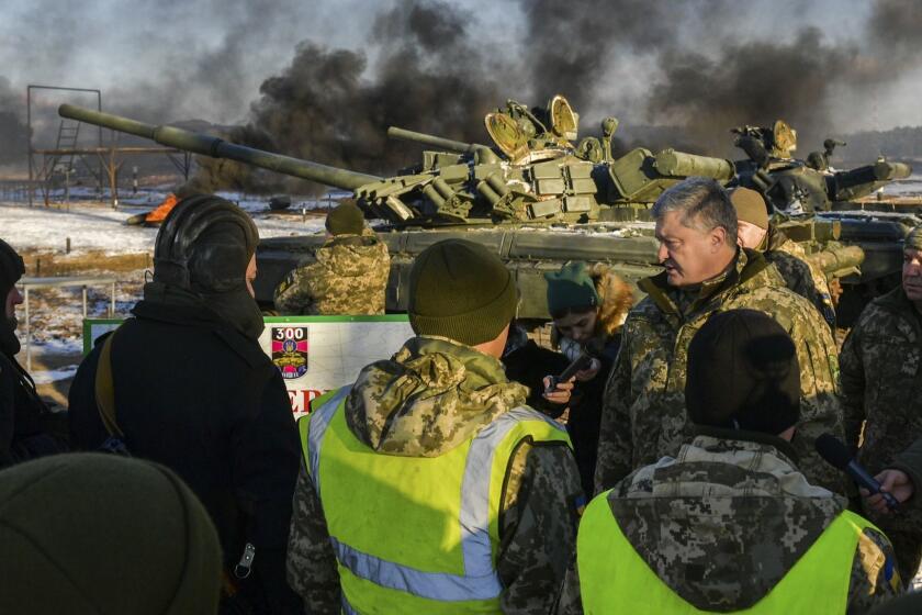 Ukrainian President Petro Poroshenko, second from right, speak with soldiers during a military training at a military base in Chernihiv region, Ukraine, Wednesday, Nov, 28, 2018. Russia and Ukraine traded blame after Russian border guards on Sunday opened fire on three Ukrainian navy vessels and eventually seized them and their crews. The incident put the two countries on war footing and raised international concern. (Mykola Lazarenko, Presidential Press Service via AP)